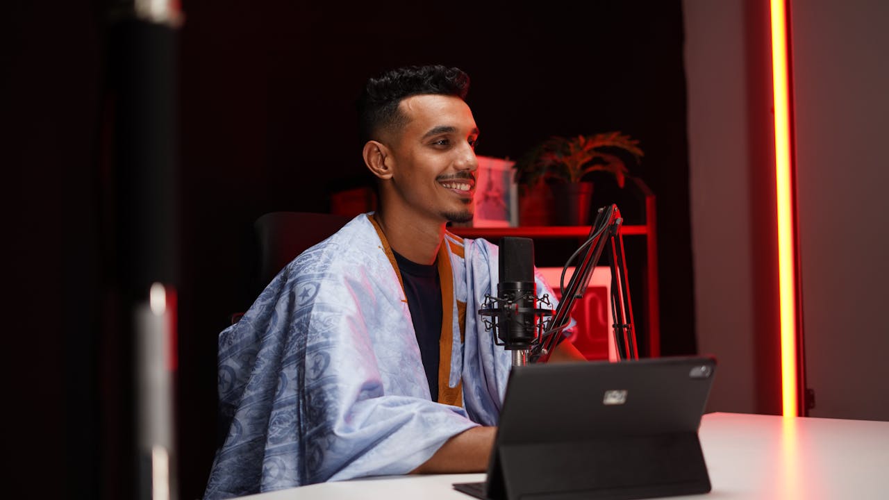 A male podcast host records in a modern studio environment, showcasing a relaxed and engaging session.